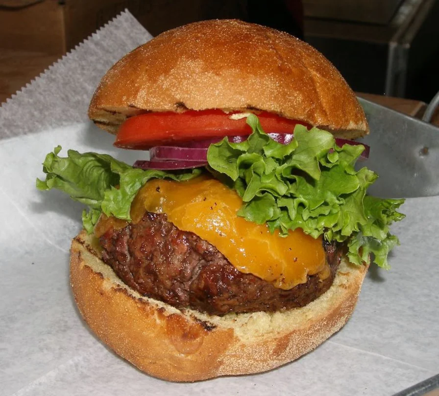 A hand made burger patty with cheese, fresh lettuce, tomato and onion from El Jefe Burger Shack.