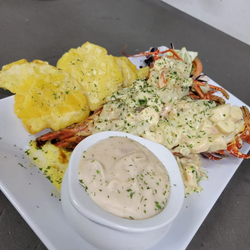 Stuffed lobster tail with a side of fried plantains available at Terruno Restaurant
