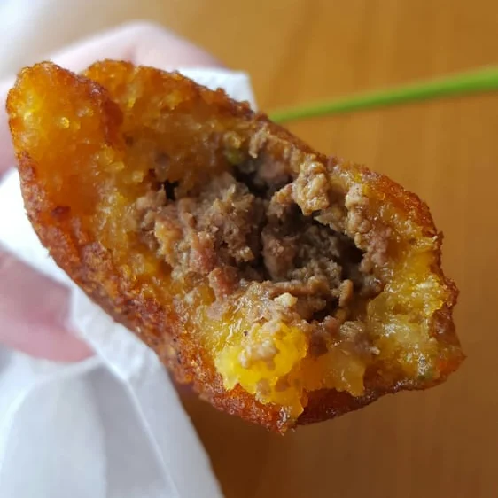 A close up of a beef filled fried snack from Antojito restuarant.