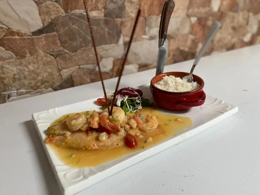 A shrimp dish with a small side salad and side of rice available at Tradiciones restaurant.