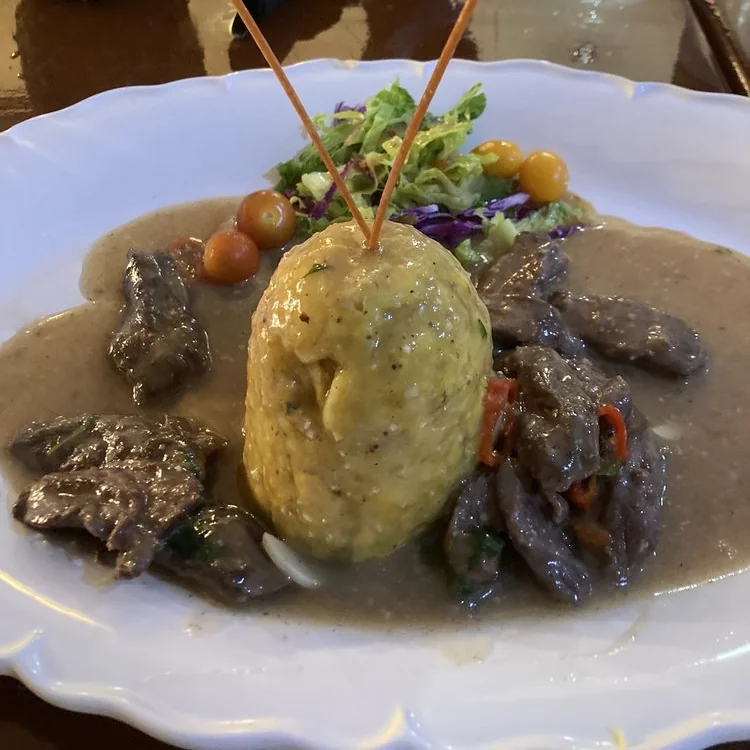 Mofongo with beef in a light sauce with a small side salad available at Tradiciones restaurant.