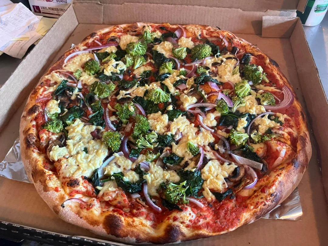 A completely vegan pizza made with home made vegan cheese available at Revolution Pizza shop.