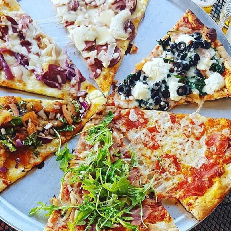 Revolution pizza shop offers a wide variety of pizza toppings, including many vegetarian options.
