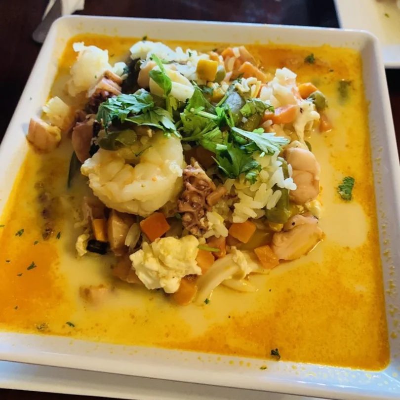 A seafood dish served with rice, vegetables, and a lite broth available at Ceviche Hut Peruvian Cuisine.