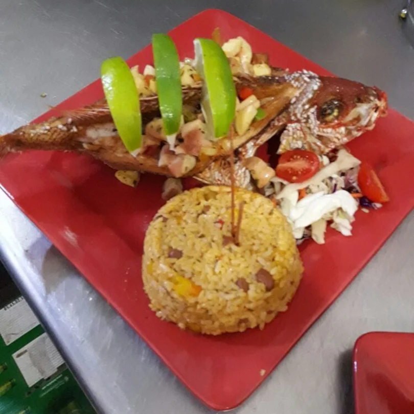 A fried fish with a side of rice and beans from El Brindis Kiosko En Otro Mundo.