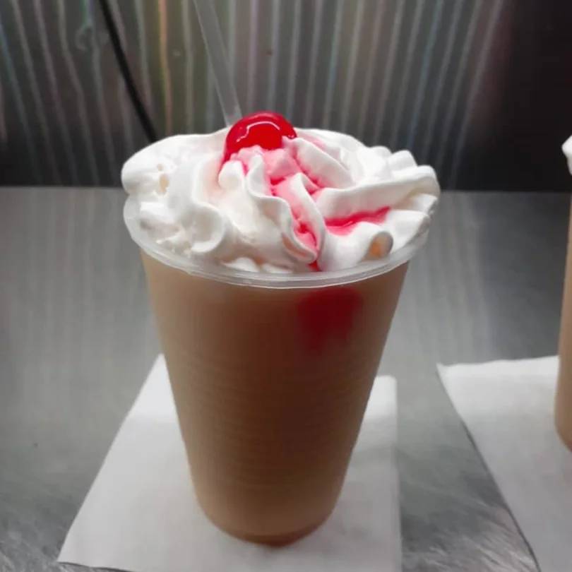 A blended mixed drink with whipped cream and a cherry on top from Bikini Bar.