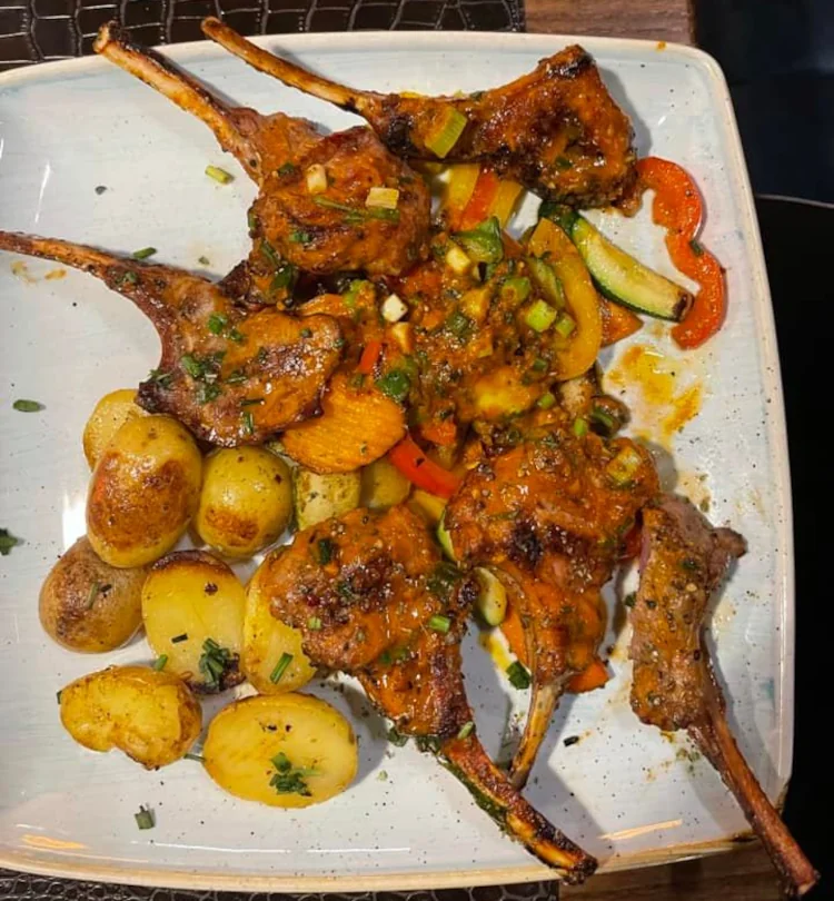 Cooked meat with roasted potatos and vegetables available at A-Fuego Bar and Restaurant