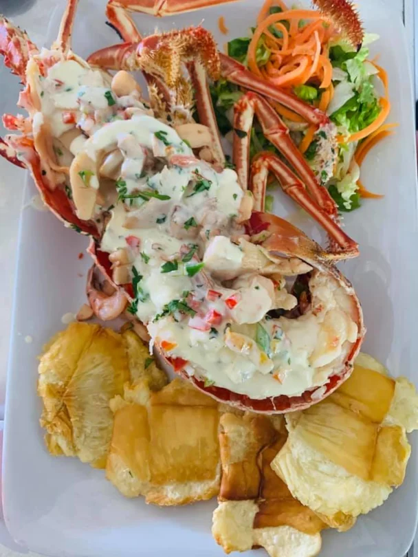 Stuffed lobster tail with a fresh salad and fried plantains available at A-Fuego Bar and Restaurant.