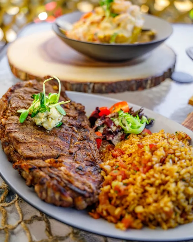A large steak with a side salad and a large side of rice and beans available at Nativa Latin Cuisine